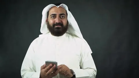 Arab businessman with beard checking his phone and smiling Stock Footage 134293781