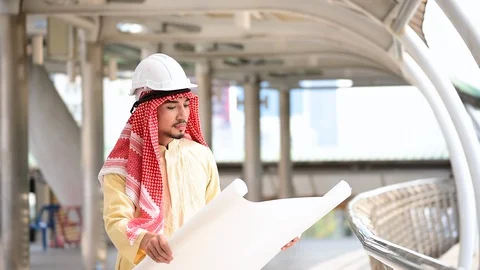 Arab civil engineer construction project hold blueprint, pointing at constructio Stock Footage 124888549