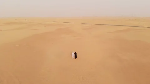 Arab couple walking in a desert Stock Footage 94461922