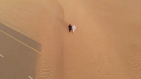 Arab couple walking in a desert Stock Footage 94462086