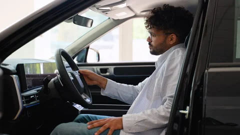 Arab customer testing new car features in dealership Stock Footage 315081827