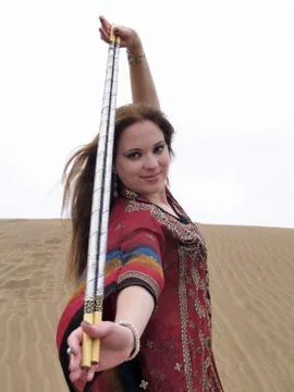 Arab dancer in red robe showing batons Stock Photos