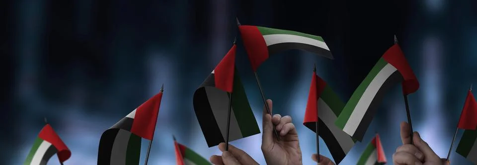 Arab Emirates flags in their hands on a blurred urban background Illustrazione stock