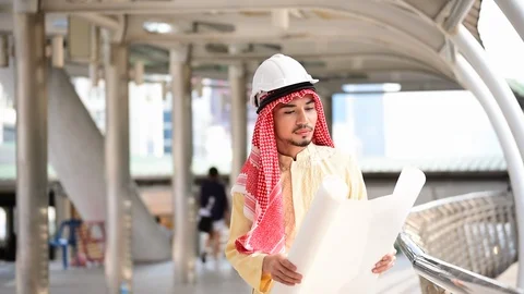 Arab engineer consult construction project together hold blueprint, pointing at  Stock Footage 124892276
