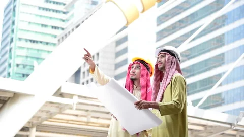 Arab engineer consult construction project together hold blueprint, pointing at  Stock Footage 137633610