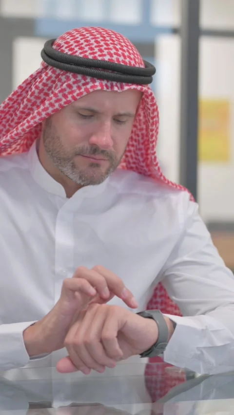 Arab Man Browsing Internet on watch in Office, vertical video Stock Footage 324708442