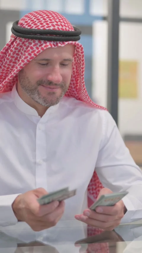 Arab Man Counting Money at Work, vertical video Stock Footage 324777383