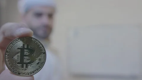 Arab man draws a chart and shows a bitcoin. Bitcoin is a worldwide Video stock 87835592