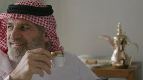 Arab man drinking Gawa and messaging on his mobile. 스톡 동영상 88094886