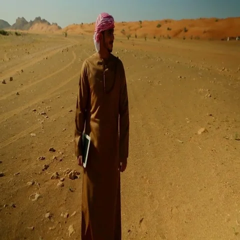 Arab man holding digital tablet and walking on desert. Video stock 69480850