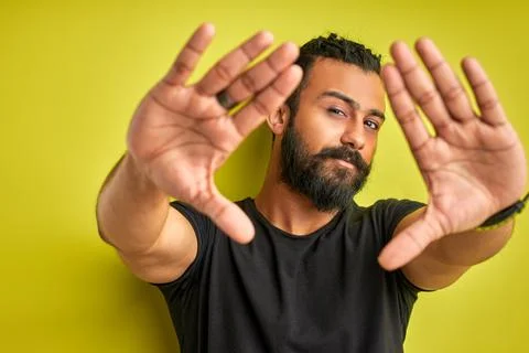 Arab man is making frame with hands and fingers with confident face Stock Photos