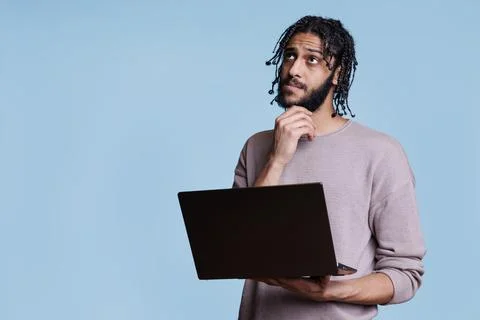 Arab man reading programming report on laptop Foto stock