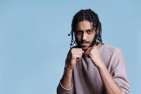 Arab man standing in boxing position with clenched fists Foto stock