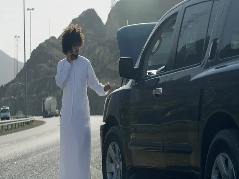 Arab man talking on mobile next to broken down car. Stock Footage 69476944