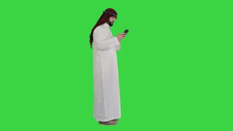 Arab man using his smartphone surfing on the internet or messaging on a Green 스톡 동영상 138525476