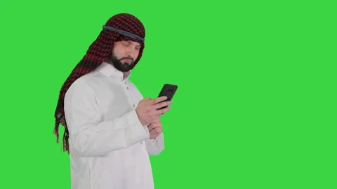 Arab man using his smartphone surfing on the internet or messaging on a Green Stock-Footage 139549812
