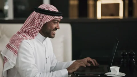 Arab man using a laptop at a cafe 스톡 동영상 105803498