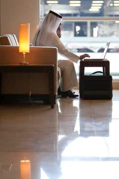 Arab man using a laptop computer in modern building Stock Photos