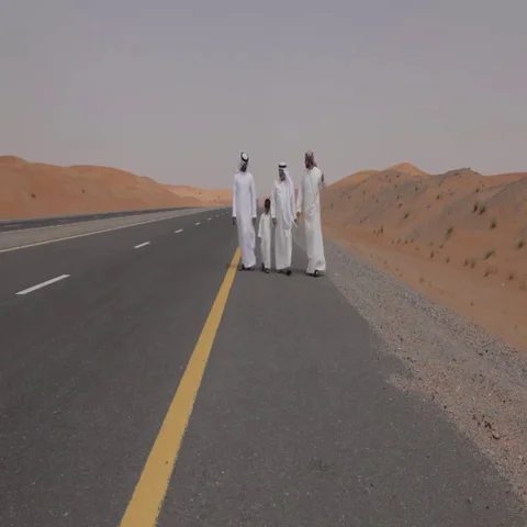 Arab men walking down the desert highway. Stock Footage 69484041