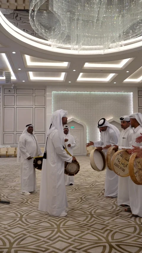 Arab men in white thobes perform a traditional sword dance and play frame drums Stock Footage 341141886