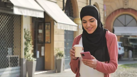 Arab middle easter female using smartphone walking city street Stock Footage 278394245