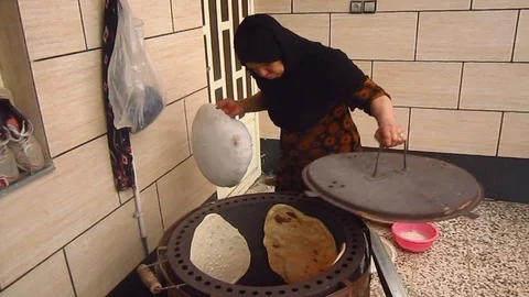 Arab old woman is baking a bread in a traditional oven Stock-Footage 114643089