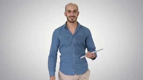 Arab presenter walking with digital tablet swiping pages on it o Stock Photos