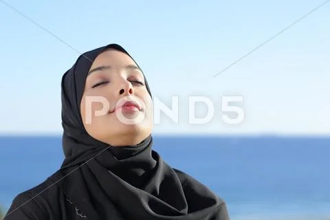 Arab saudi woman breathing deep fresh air in the beach Stock Photos