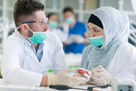 Arab students with hijab while working on the denture, false teeth. Stock Photos