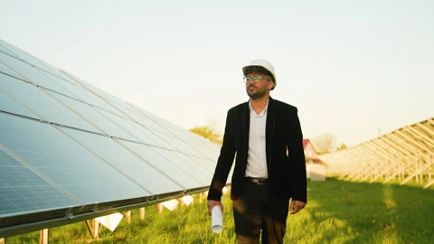 Arabian engineer walking near solar panels in a field Stock Footage 314408512