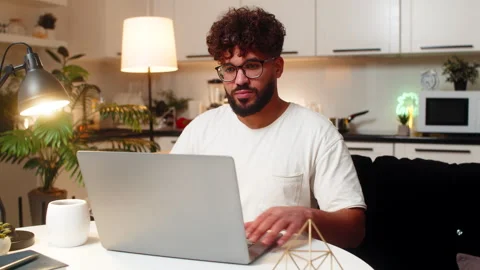 Arabian man freelance worker opens laptop starts project types fast checks Stock Footage 347038511