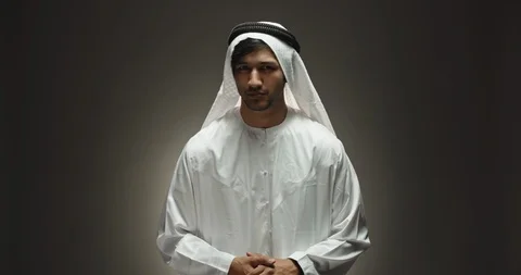 Arabian man looking at camera and positively smiling, throwing his hands wide in Video stock 127196496