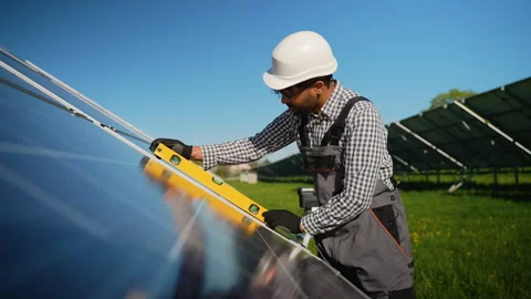 Arabic engineer installing and leveling solar panel in solar farm Video stock 314403317