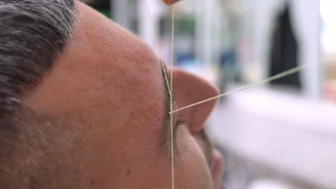 Arabic eyebrow threading by barber for client in Italy Stock Footage 318135000