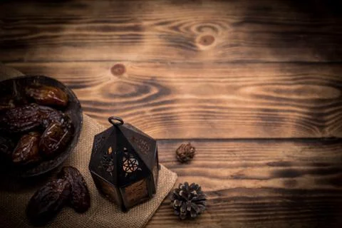 Arabic lantern with candle and date palm fruit on wood table with copy space Stock Photos