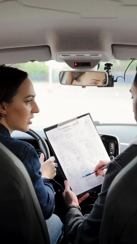 Arabic male driving instructor accepts a test from female student Stock Footage 275011991