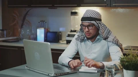 Arabic man with kandora making video call on computer working from home-office Stock Footage 157599301