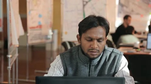 Arabic man sits at table and works on computer Stock Footage 66142096