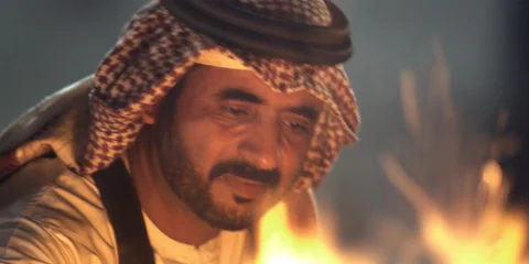 An Arabic man sitting by a camp fire. Video stock 46870846