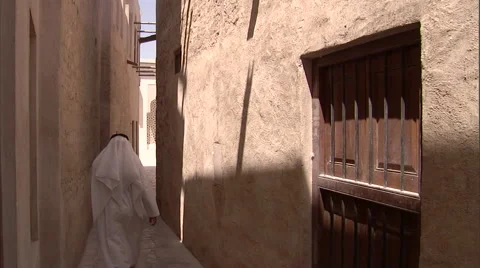 An Arabic man walks down a narrow passage in the Bastakiya area in Dubai. Video stock 46868793