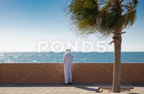 Arabic man is on the waterfront and looking at the sea Stock Photos