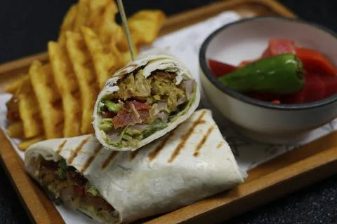 Arabic middle eastern falafel wrap with potato chips and pickle in close up Stock Photos