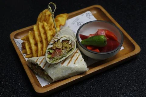 Arabic middle eastern falafel wrap with potato chips and pickle Stock Photos