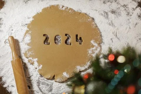 Arabic numerals 2024 cut from rolled raw brown cookie dough on white flour ag Stock Photos