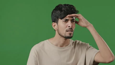 Arabic puzzled man stand on green background brunette male portrait hispanic Stock Footage 200788939