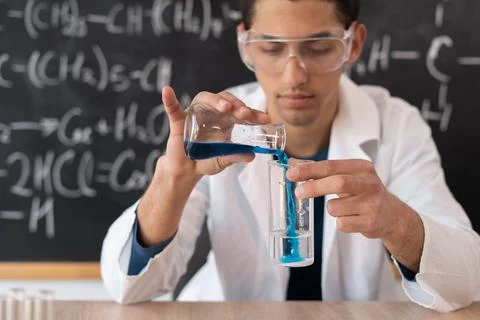 Arabic student chemist doing experiment in class, chemistry teacher connects  Stock Photos
