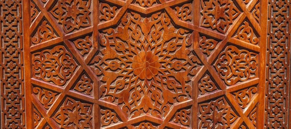 Arabic Uzbek Islamic patterns arabesque ornament on brown wooden carved door in Stock Photos
