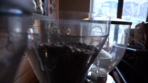 Arabica coffee beans falling into full coffee grinder Video stock 84815330