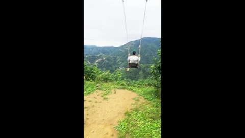 Araffe on a swing in the mountains. Stock Footage 282659107