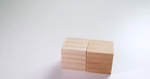 Aranging and stacking up blocks with a tiny wooden toy house on top of it. Video stock 254015533